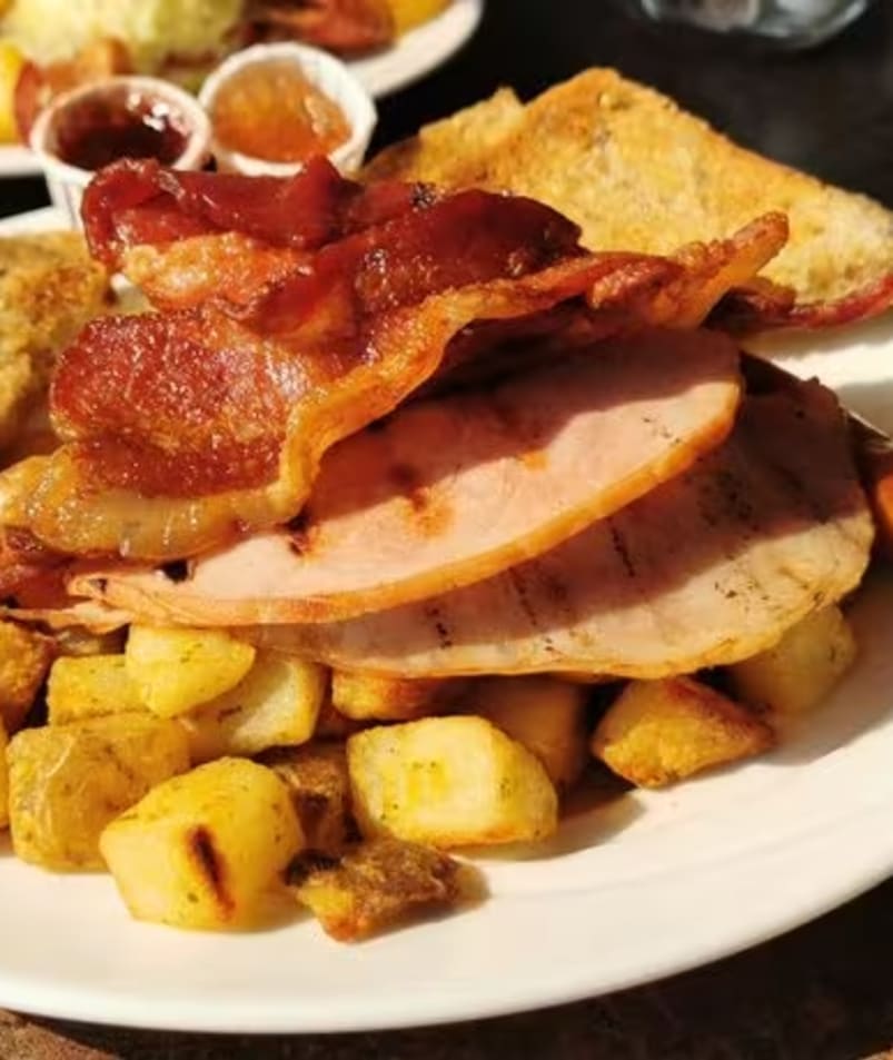 A hearty breakfast plate at The Jammery in Lake Country features bacon, ham, toast, and roasted potatoes. (