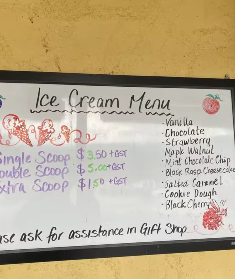 A whiteboard menu at The Jammery in Lake Country lists various ice cream flavors and prices for single, double, and extra scoops, with a note to ask for assistance in the gift shop.