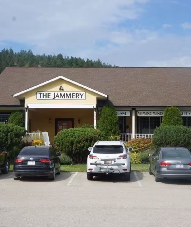 A building with a sign reading The Jammery in Lake Country, surrounded by parked cars and greenery.