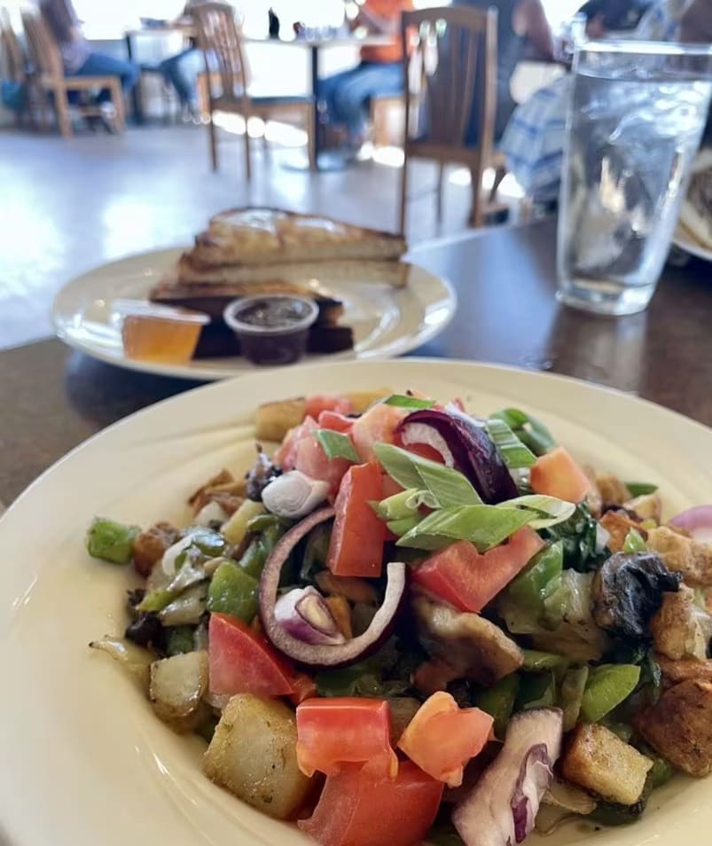 A plate of salad with various vegetables served at The Jammery in Lake Country, with another table and diners in the background.