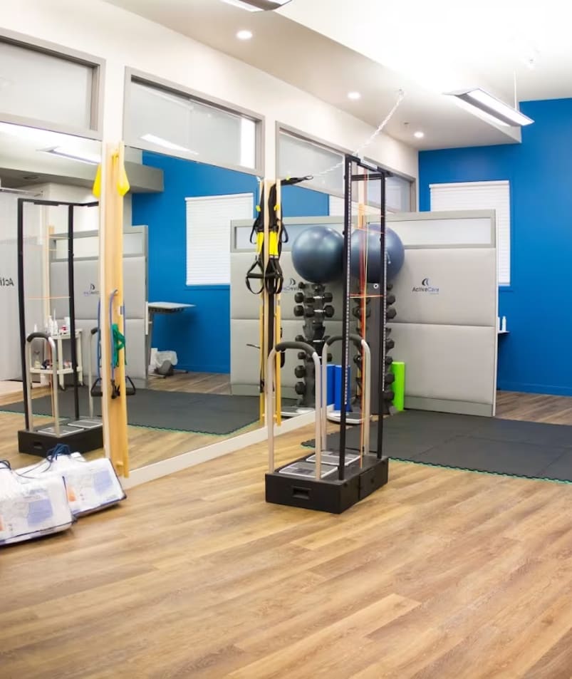 A bright and spacious exercise area at Active Care Health Centre in Kelowna with equipment and mirrors.