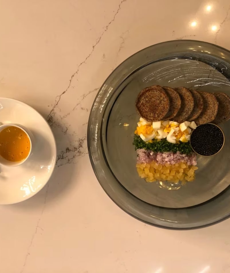 A plate with crackers, chopped eggs, parsley, onions, pickled vegetables, caviar and a dipping sauce served on the side at Erica Jane Restaurant in Kelowna.