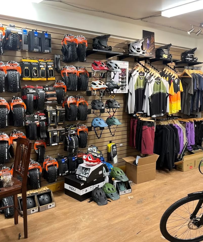 a store with a bicycle and a lot of items on the wall and a bike parked in front of it