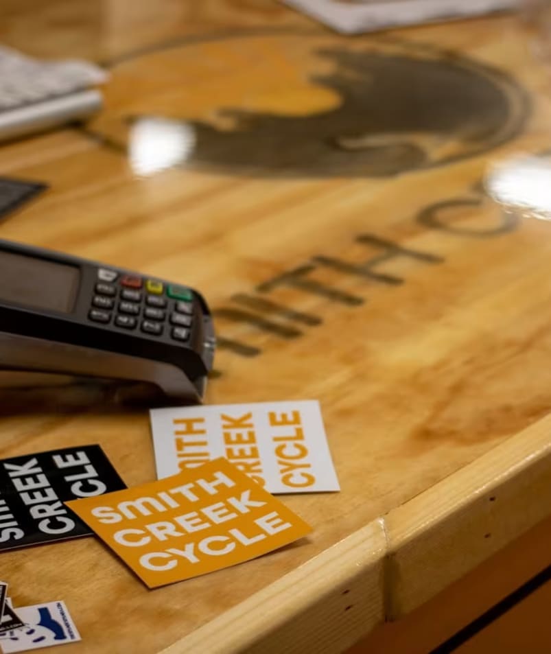 a wooden table topped with lots of stickers and a calculator on top of a wooden table