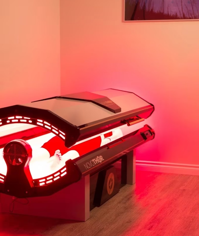 A red light therapy machine illuminated in red light at The Recovery Spa in Kelowna.