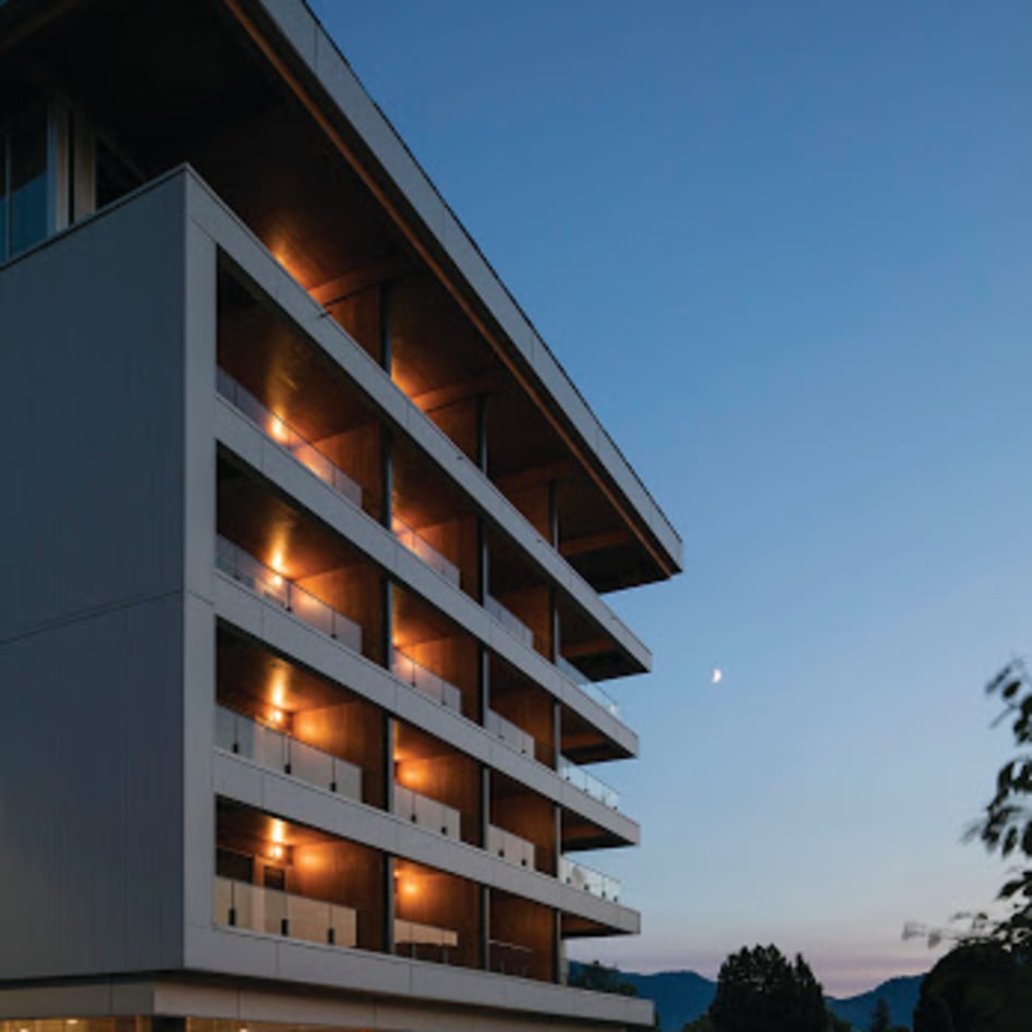 Penticton Lakeside Resort & Conference Centre at dusk, showing a multi-story building with lit balconies against a twilight sky.