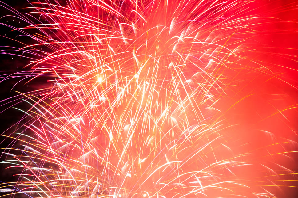 A vibrant display of red fireworks lighting up the night sky in Kelowna.