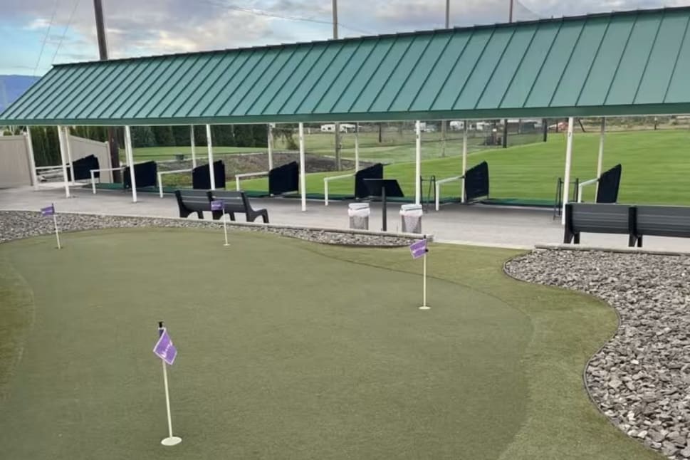 The Golf Centre Practice Facility in Kelowna with a green roof, putting green, and benches.