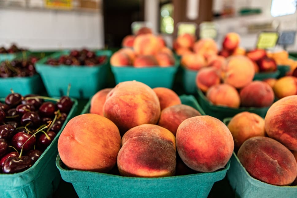 Baskets of fresh peaches and cherries displayed on a market stand in Okanagan.