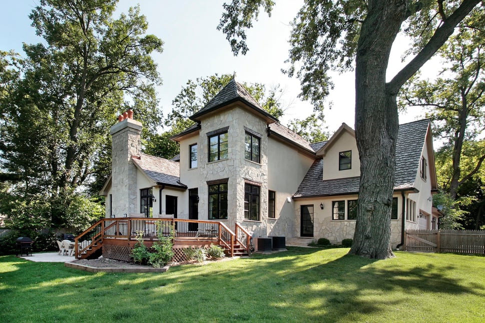 A beautiful house with a modern exterior design surrounded by a lush garden and trees.