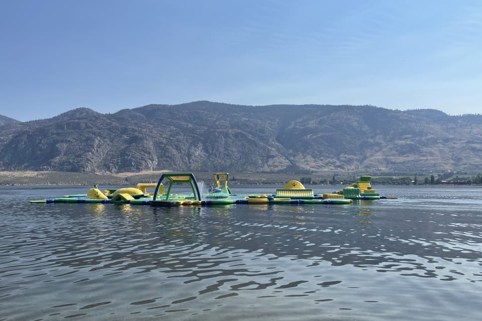 Colorful inflatable water park on a lake with mountains in the background in Osoyoos.