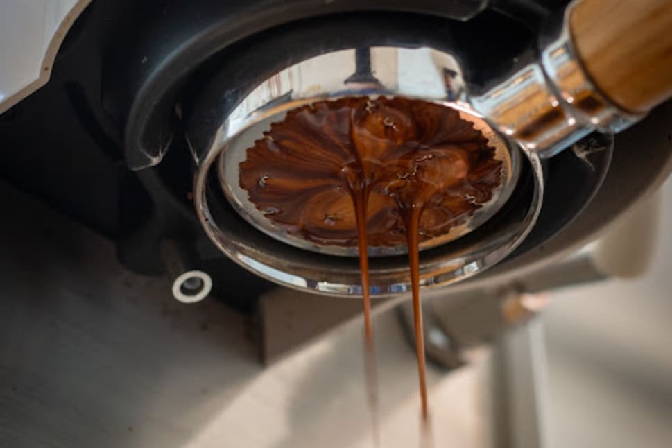 A close-up of espresso pouring from a portafilter into a cup at a coffee shop in Vernon.