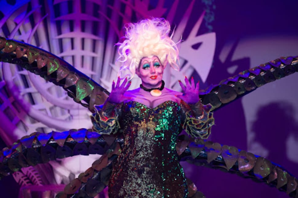 A performer dressed as a flamboyant character with tentacles and dramatic makeup on stage at Kelowna Actors Studio.
