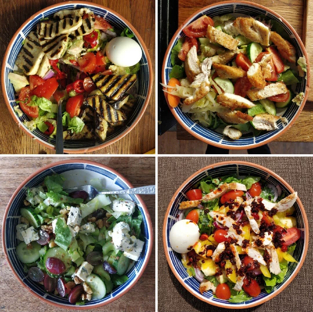 Four bowls full of various combinations of protein and salad.