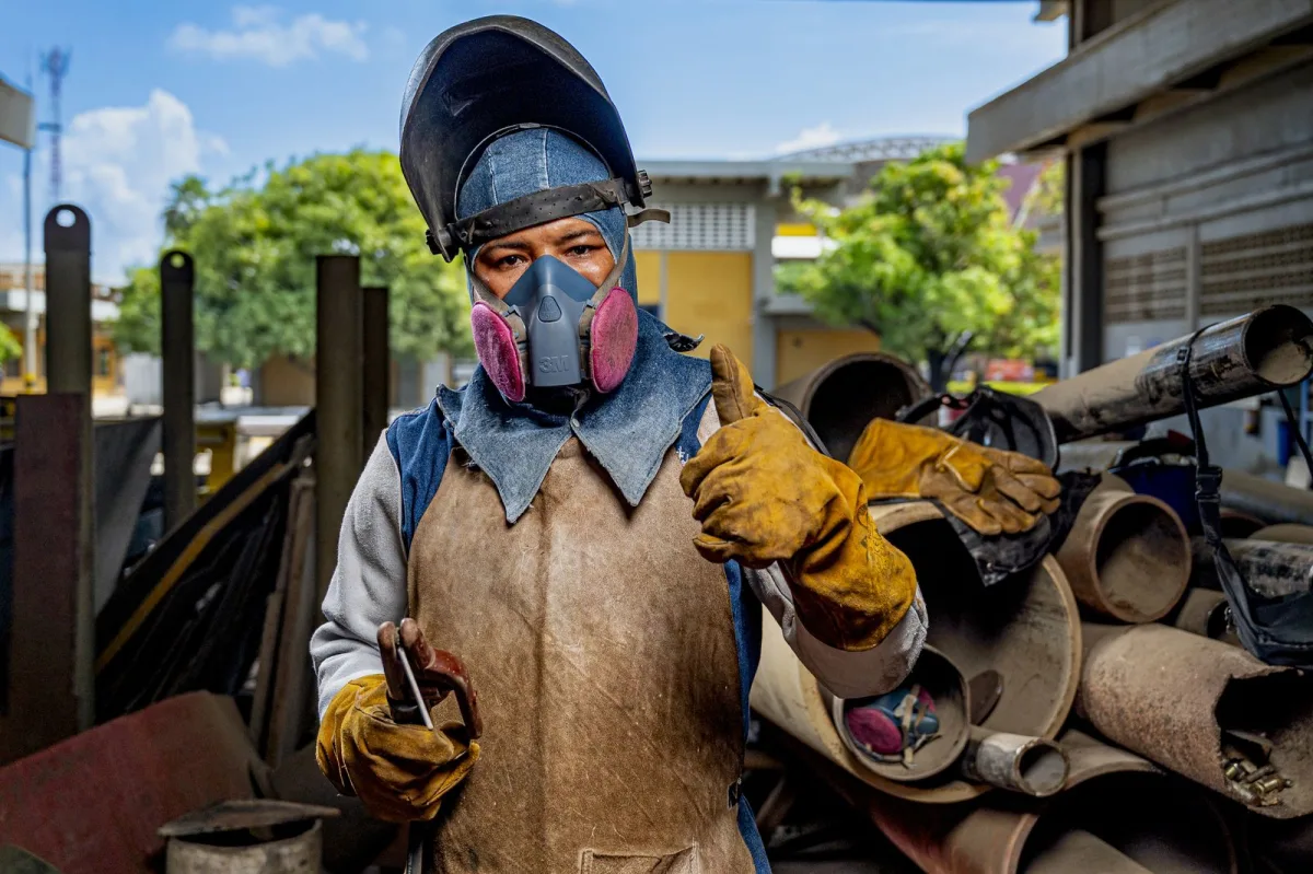 Soldador con máscara trabajando con un soplete en un astillero de COTECMAR