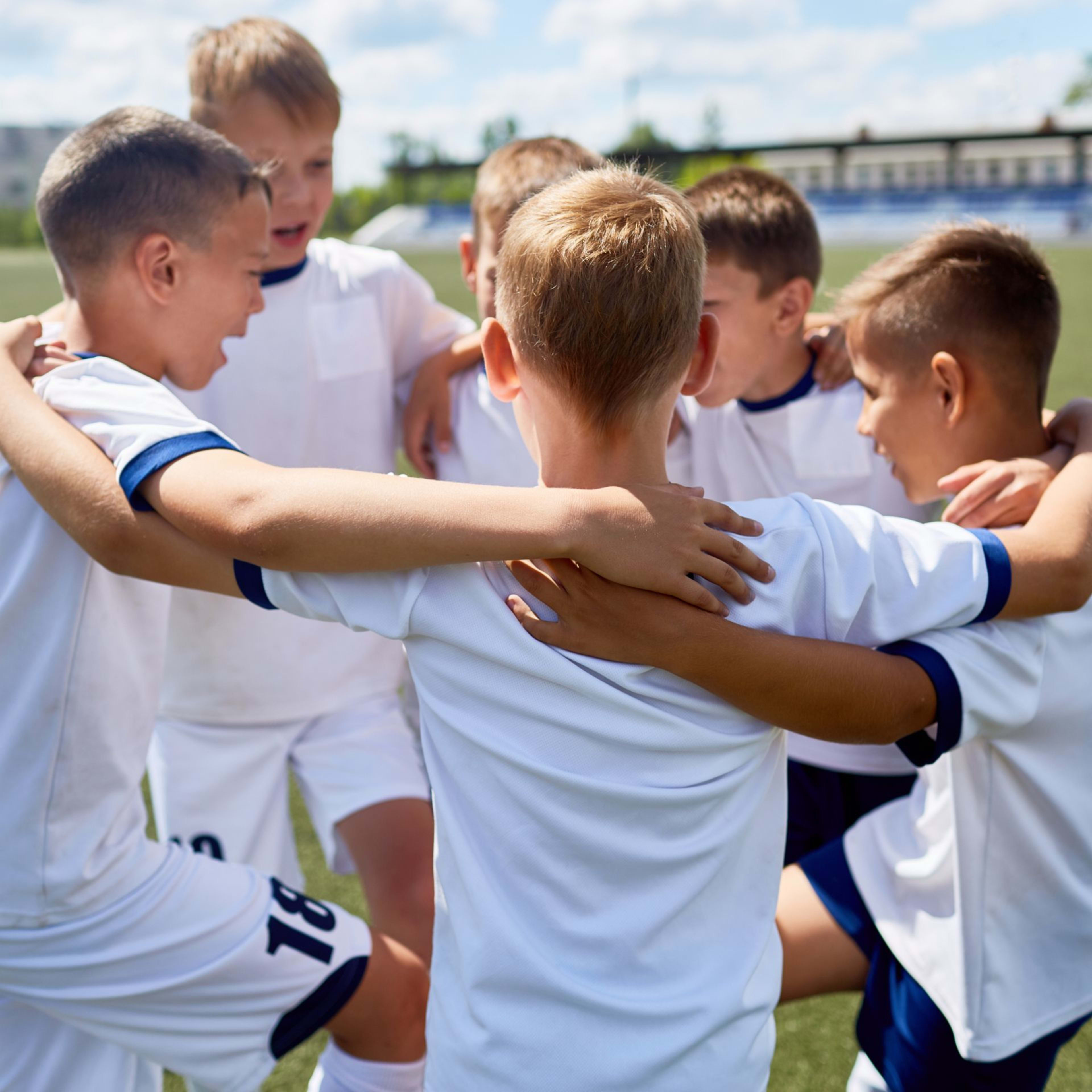 Eine Gruppe von Kindern in einem Kreis und sich gegenseitig an den Schultern halten