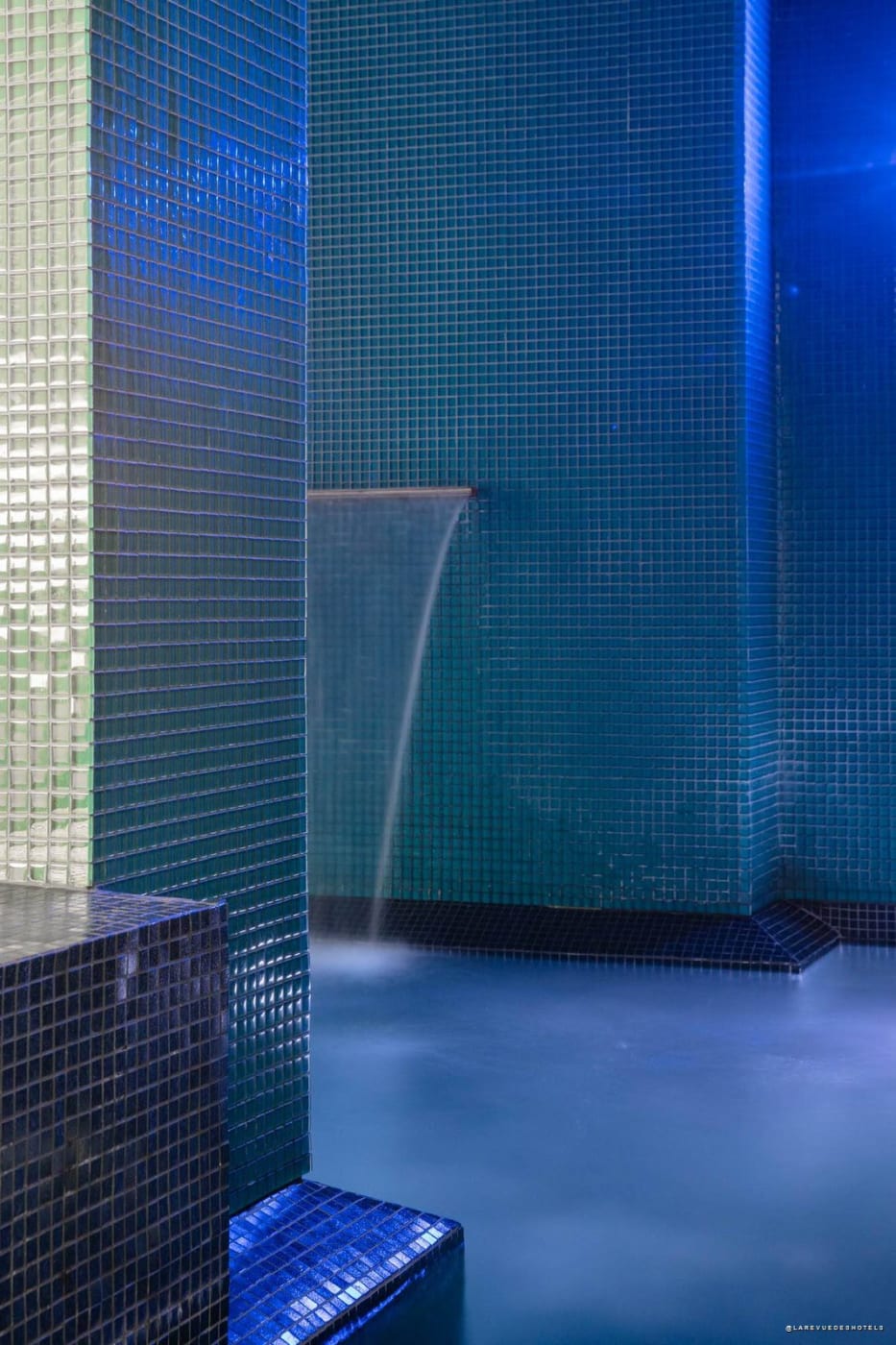 Water feature above the blue mosaic pool at Hôtel C2