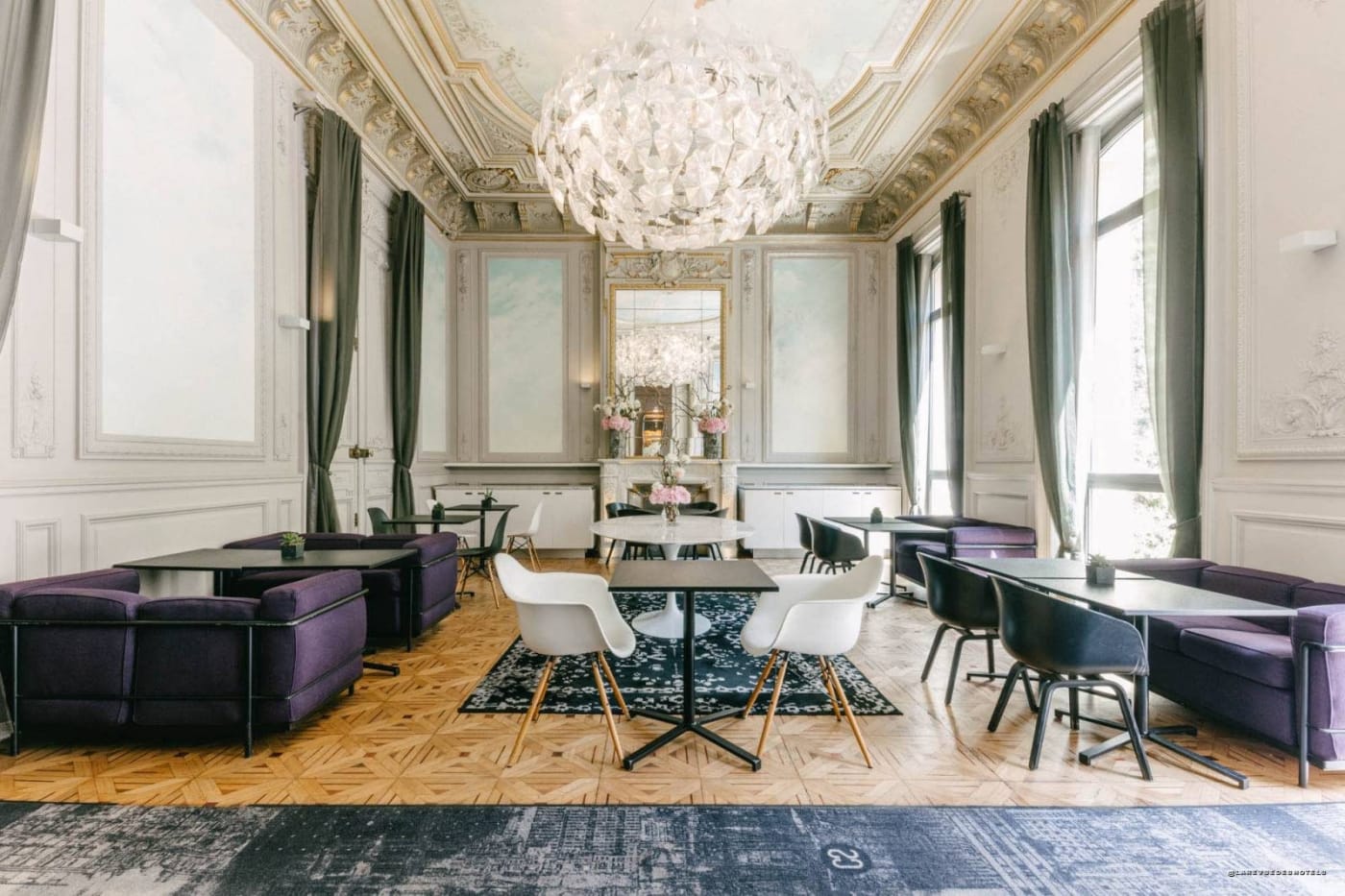 Grand lounge at Hôtel C2, 19th-century mouldings, contemporary chandelier and purple sofas