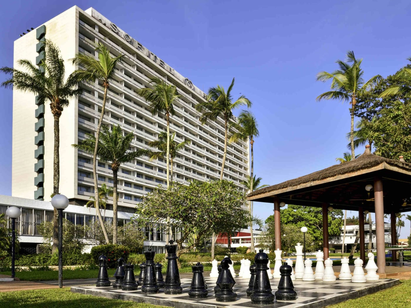 El edificio del Sofitel Abidjan Hôtel Ivoire visto desde los jardines y sus palmeras