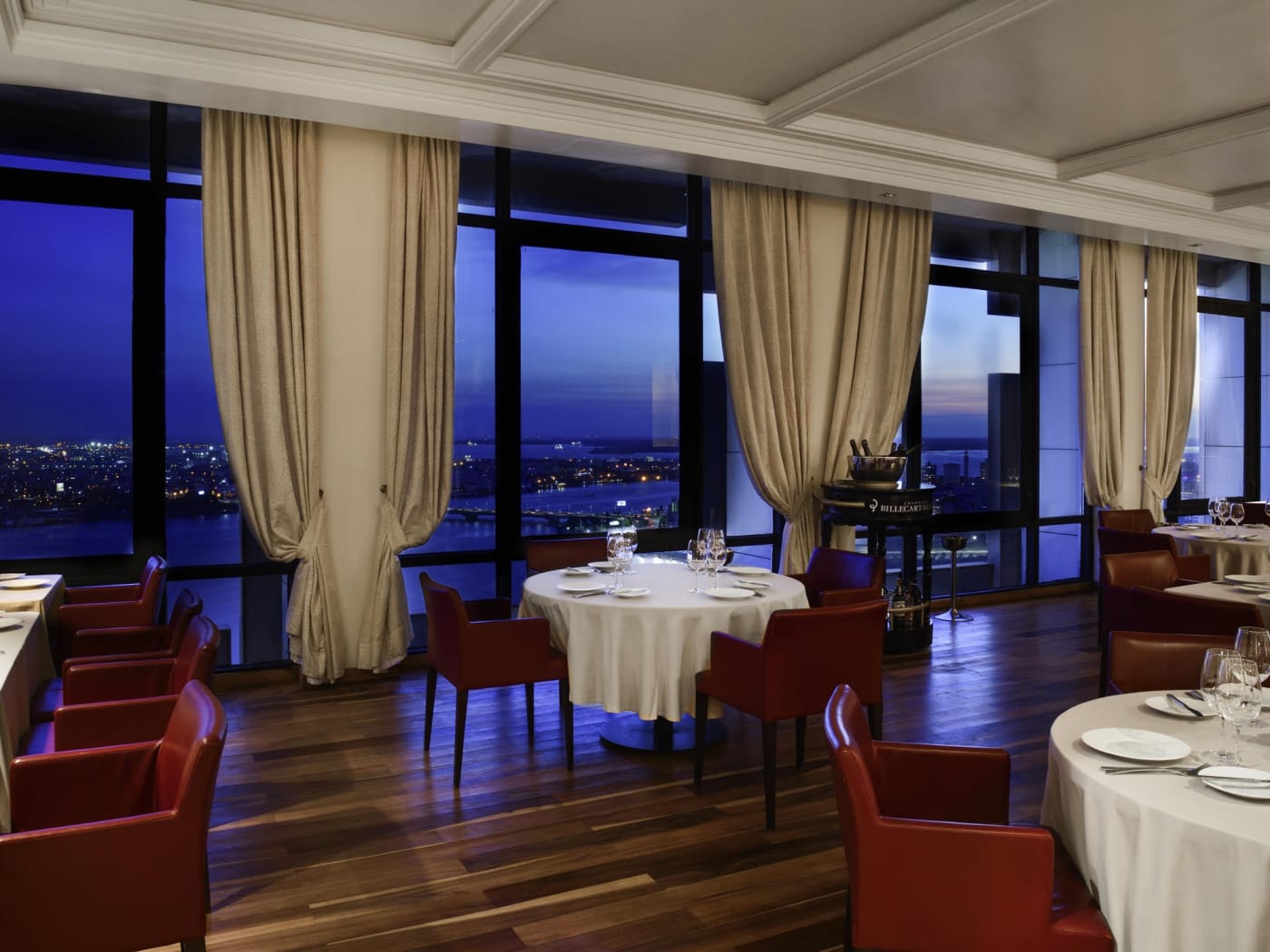 Un restaurante en una planta superior del Sofitel Abidjan Hôtel Ivoire, con ventanales a la laguna Ébrié