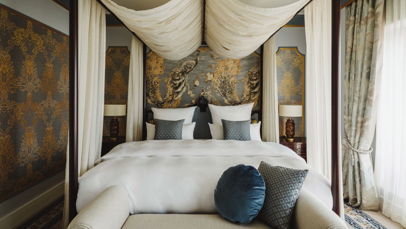 Chambre de suite du Taj Hessischer Hof, lit à baldaquin et tête de lit brodée de paons