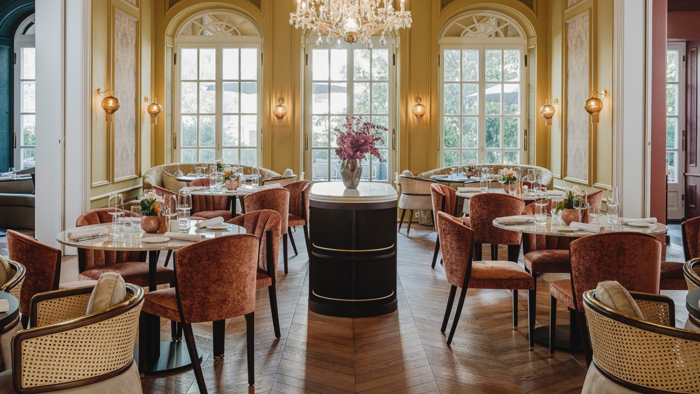 Salle à manger aux murs jaunes et lustre en cristal au Taj Hessischer Hof