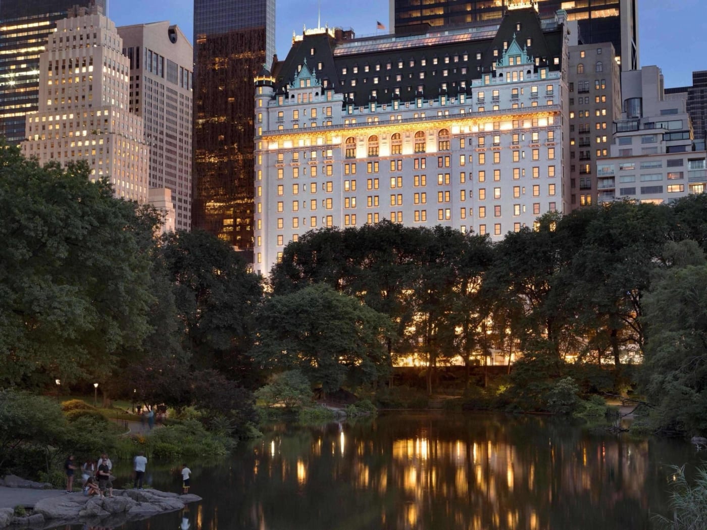 Façade illuminée à la tombée de la nuit, vue depuis l'étang de Central Park