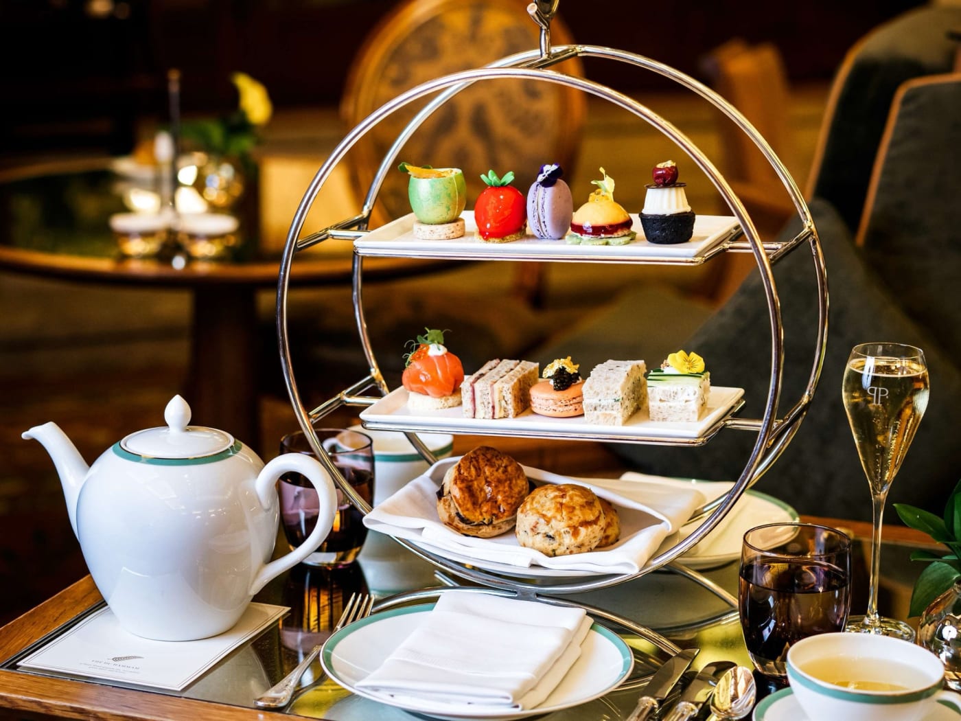 Afternoon tea : présentoir à trois étages, scones, sandwichs, pâtisseries, théière et coupe de champagne