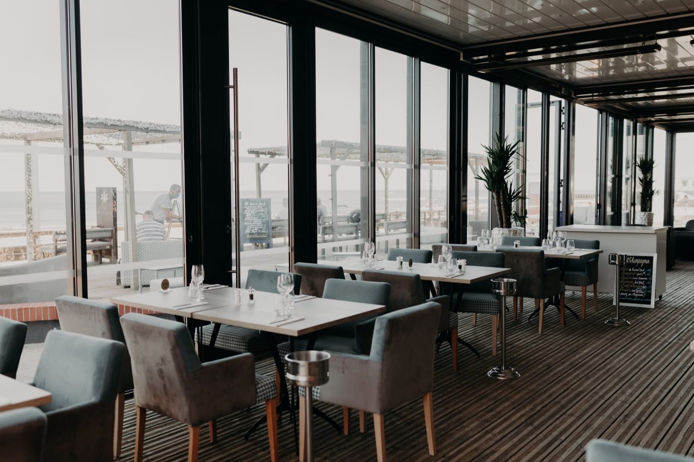 The glass-walled restaurant of the Baya Hôtel in Capbreton, tables set facing the seafront