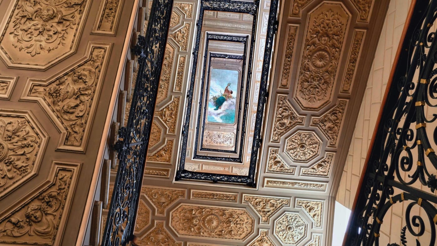The historic staircase of the St. Regis Rome, gilded ceilings and wrought-iron banister