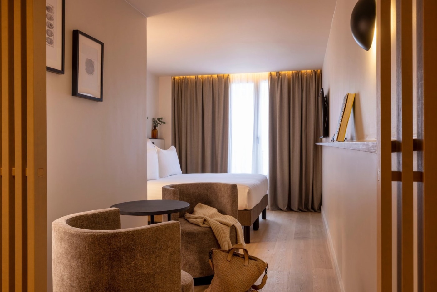 Habitación superior del Hôtel Esté en tonos arena, con sillones de terciopelo y parqué claro, cerca de la Gare de l'Est, en el distrito 10 de París