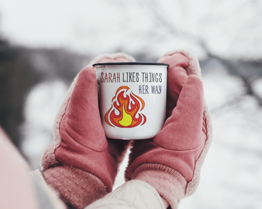 hands in gloves with custom enamel mug