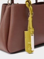 Bolso tote liso con colgante por 9.99€.
