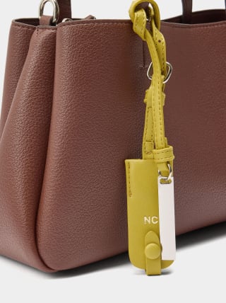 Bolso tote liso con colgante por 9.99€.