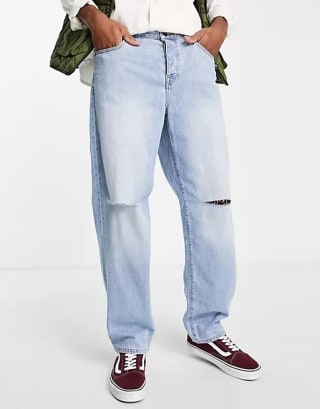 ASOS DESIGN - Ruimvallende jeans in mid-wash blauw met scheuren op de knie voor €15 dmv code bij Asos
