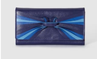 Cartera en piel de color azul con cierre de solapa y detallle anudado multicolor en tonos azules por 10€