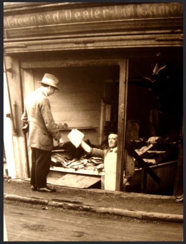 A butcher's shop serves a customer from below ground level. Photo from Stubby43