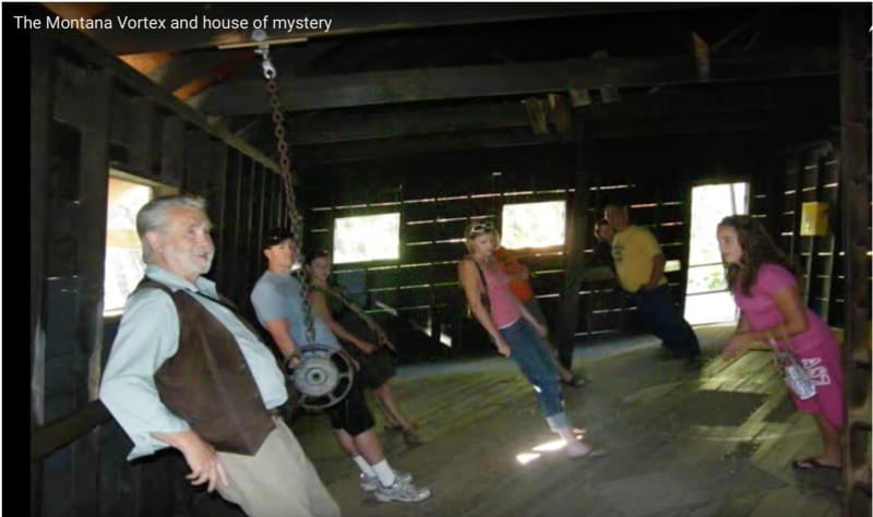 Visitors experience strange forces at the Montana House of Mystery. Why does the chain hang at a different angle from the angle at which the people stand?