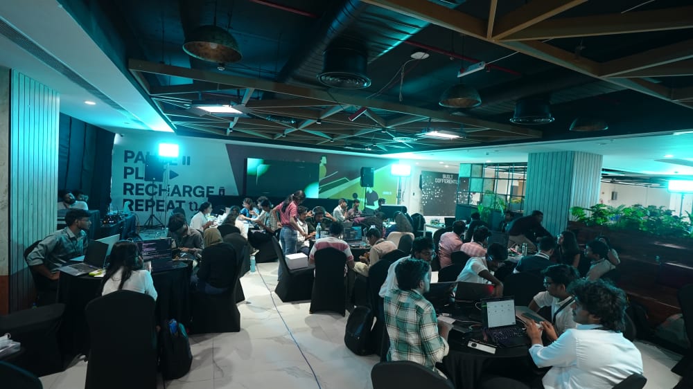 Wide view of Makers Conclave teams gathered on the expo floor during a briefing