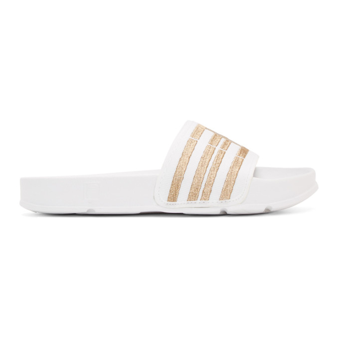 white and gold fila slides