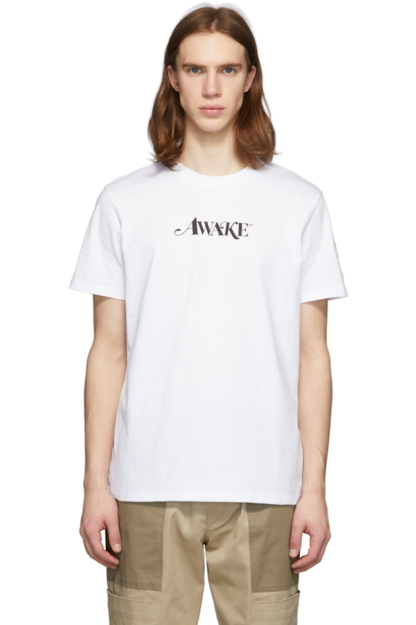 Short sleeve cotton jersey t-shirt in white. Rib knit crewneck collar. Printed text in black at chest. Embroidered felt logo patch in off-white, navy, and red at sleeve. 

Part of the 2 Moncler 1952 collection in collaboration with Awake NY. 

Supplier color: White