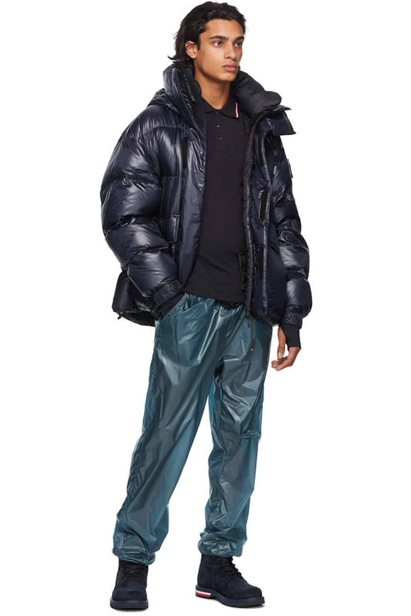 Long sleeve down-filled quilted technical ripstop coat in navy. Bungee-style drawstring at hood. Concealed zip closure with Velcro placket at front. Flap pockets and zippered pockets at waist. Detachable embroidered logo patch in black with Velcro fastening. Adjustable press-stud tab and thumb opening at integrated bonded jersey cuffs. Zippered pocket at interior featuring headphone wire opening. Integrated adjustable harness in black at interior with press-release buckle fastening. 

Supplier color: Blue

Fill: 90% goose down, 10% feathers.
