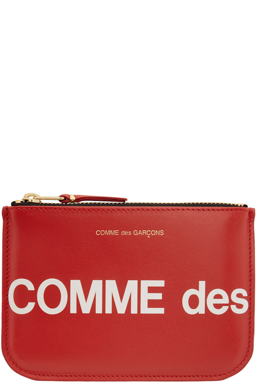 Buffed leather pouch in red. Gold-tone logo stamp at face. Logo printed in white at front and back face. Zip closure. Leather lining in black. Gold-tone hardware. Approx. 5.75" length x 4" height.

Supplier color: Red