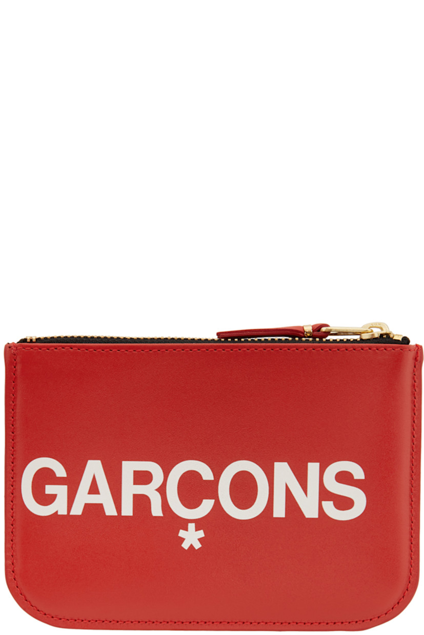 Buffed leather pouch in red. Gold-tone logo stamp at face. Logo printed in white at front and back face. Zip closure. Leather lining in black. Gold-tone hardware. Approx. 5.75" length x 4" height.

Supplier color: Red