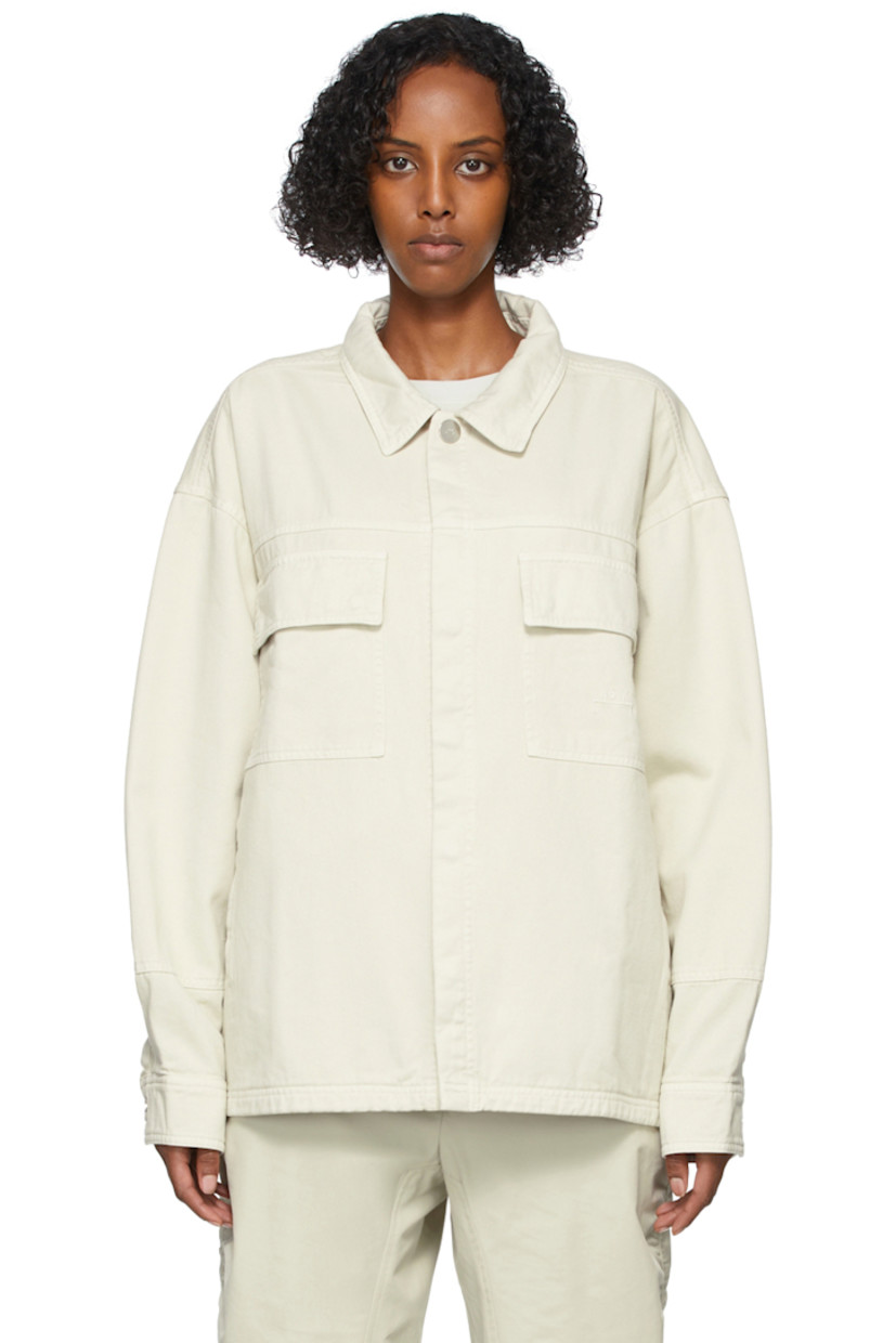 Long sleeve cotton twill jacket in beige. Spread collar. Concealed press-stud closure at front. Flap pockets and tonal embroidered logo at chest. Zippered pockets at waist. Two-button barrel cuffs. Central vent at back hem. Unlined. Logo-engraved silver-tone hardware. 

Supplier color: Bone