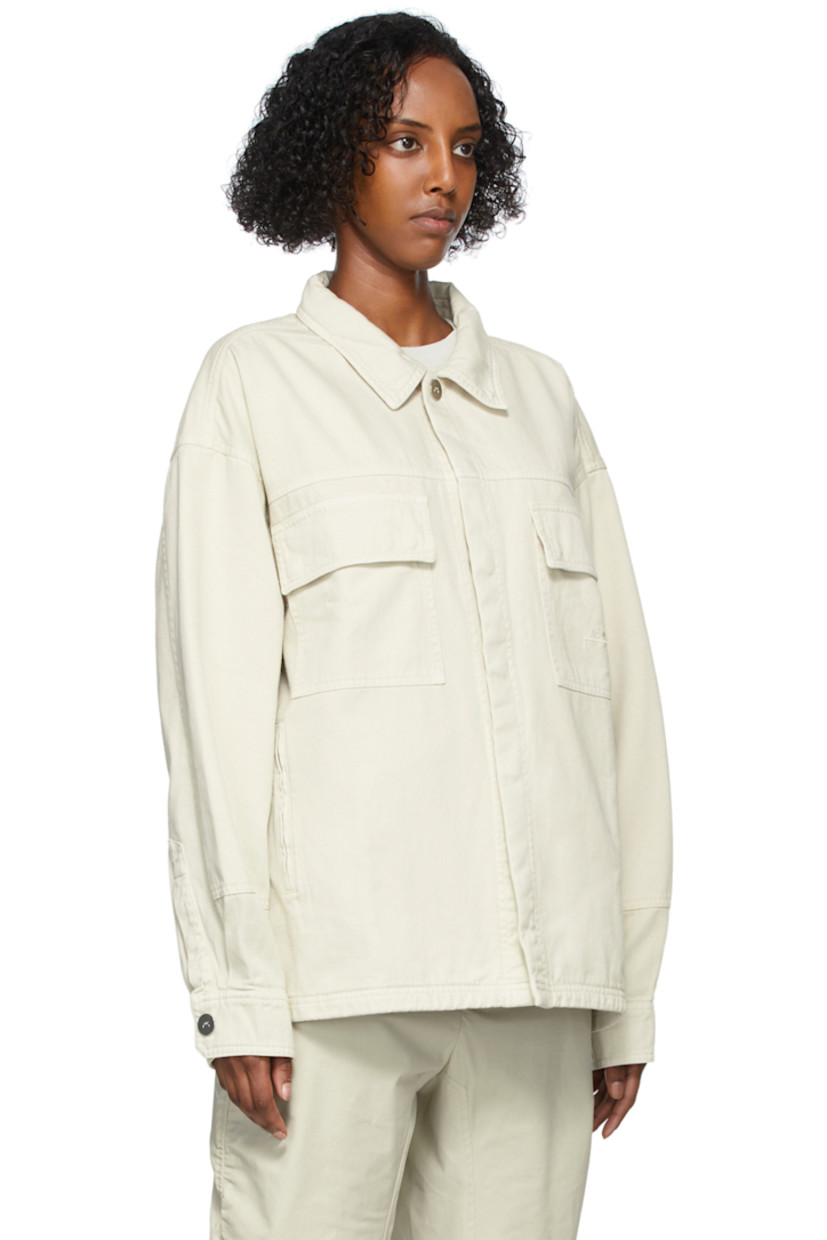 Long sleeve cotton twill jacket in beige. Spread collar. Concealed press-stud closure at front. Flap pockets and tonal embroidered logo at chest. Zippered pockets at waist. Two-button barrel cuffs. Central vent at back hem. Unlined. Logo-engraved silver-tone hardware. 

Supplier color: Bone
