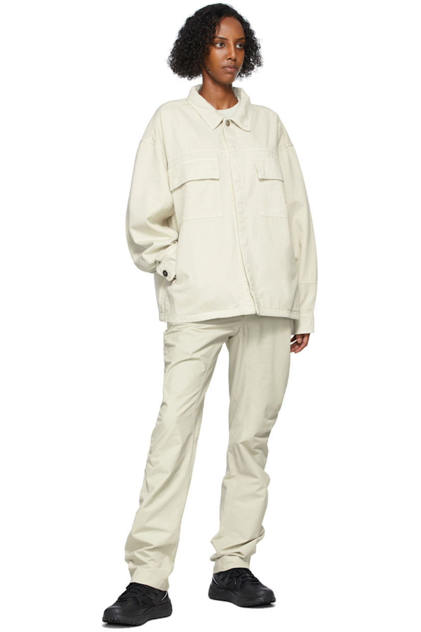 Long sleeve cotton twill jacket in beige. Spread collar. Concealed press-stud closure at front. Flap pockets and tonal embroidered logo at chest. Zippered pockets at waist. Two-button barrel cuffs. Central vent at back hem. Unlined. Logo-engraved silver-tone hardware. 

Supplier color: Bone