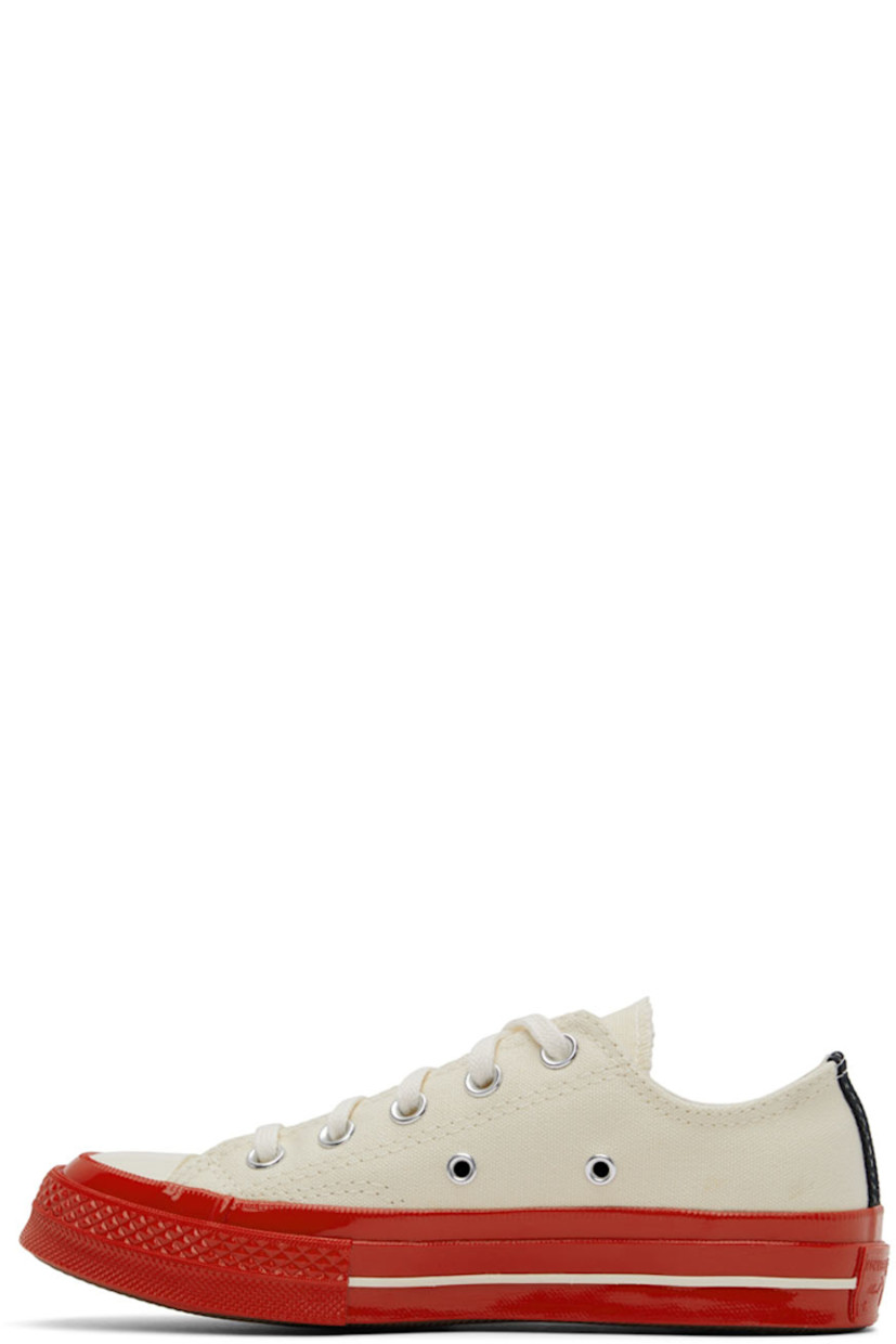 Low-top canvas sneakers in off-white.

· Round rubber cap toe
· Lace-up closure
· Logo graphic printed at outer side
· Eyelet vents at inner side
· Webbing trim in black at heel
· Logo embossed at heel 
· Rubber midsole in red
· Treaded rubber outsole in brown

Part of the Comme des Garçons Play x Converse collaboration.

Supplier color: Off white