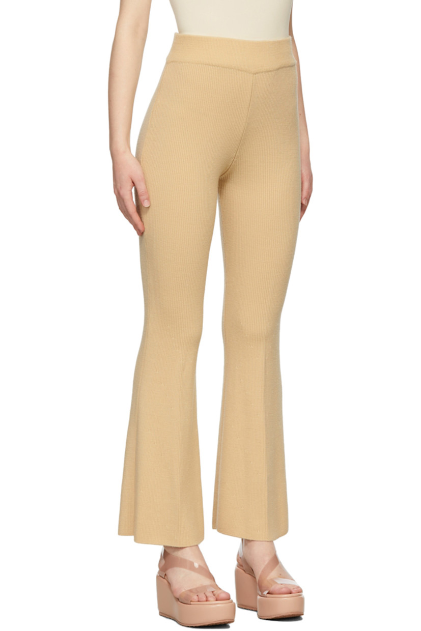 Flared rib knit wool pants in beige. 

· High-rise 
· Elasticized waistband 

Supplier color: Yellow beige