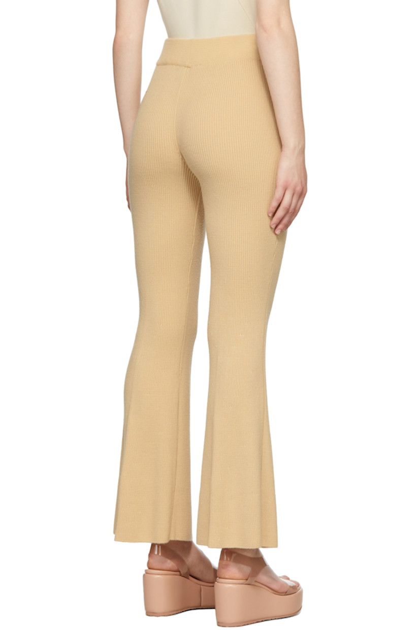 Flared rib knit wool pants in beige. 

· High-rise 
· Elasticized waistband 

Supplier color: Yellow beige
